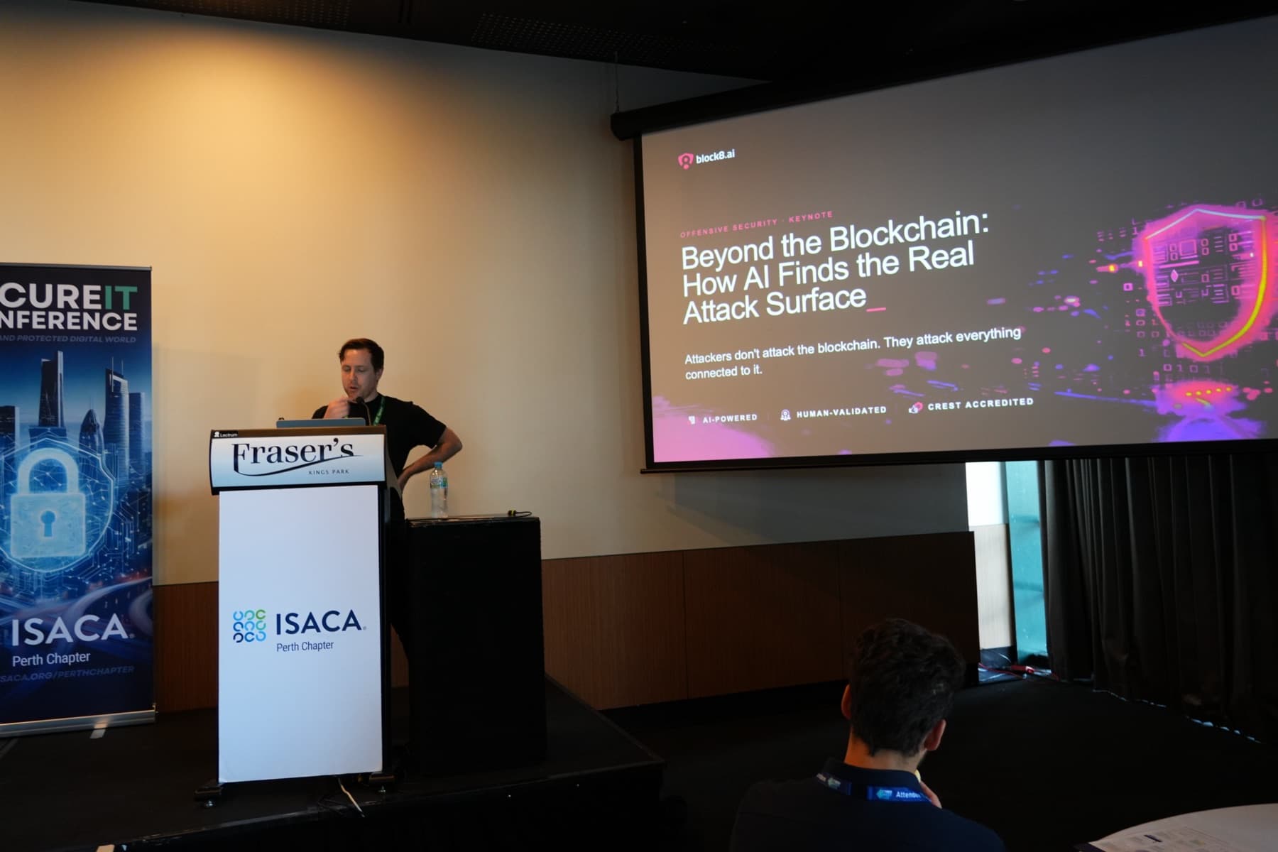 Bob Ledger speaking at a lectern beside a Block8.ai slide titled Beyond the Blockchain, How AI Finds the Real Attack Surface